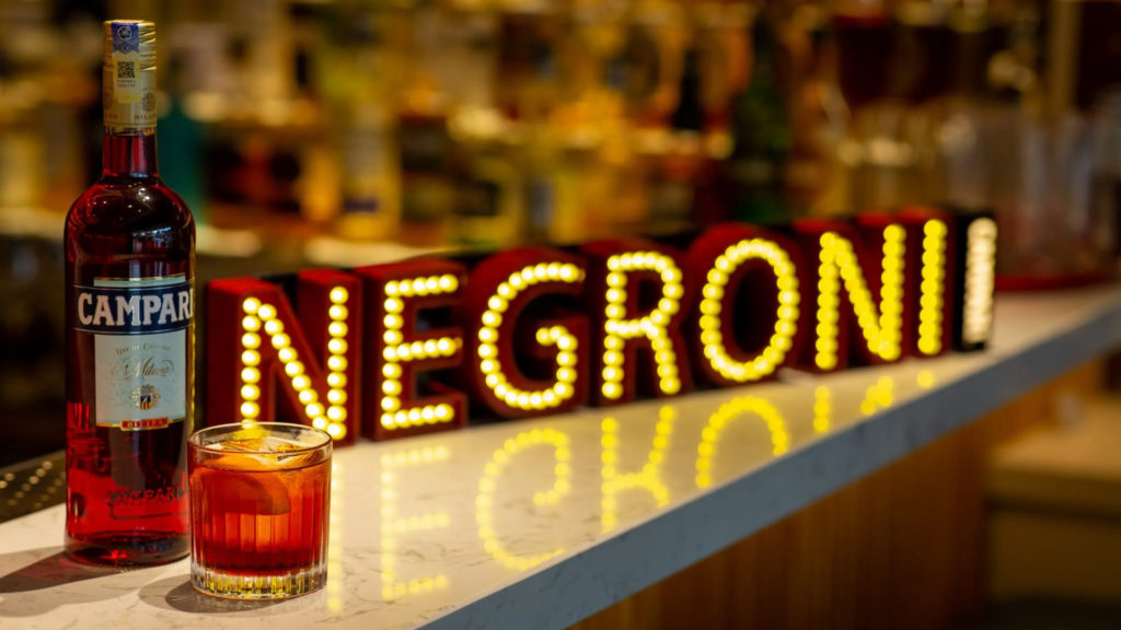 Image of Campari bottle and glass of Negroni supporting Negroni Week.